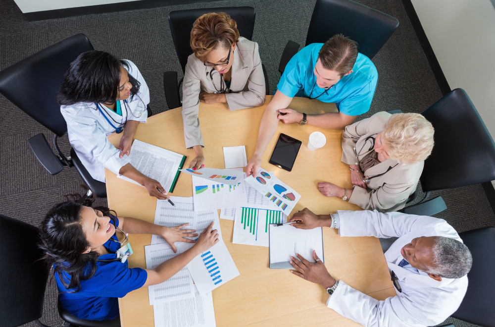 Group of medical professionals sitting around a table working with files